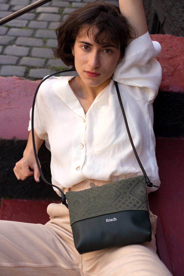 Model mit dunkelgrüner kleiner Handtasche von frisch Beutel
