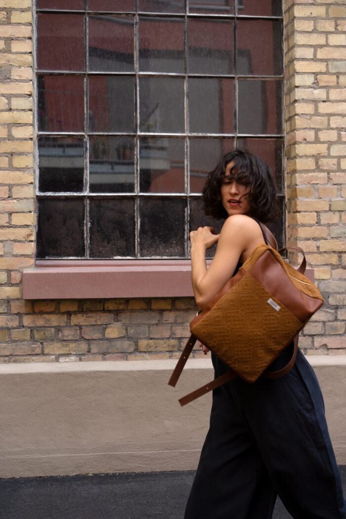 Tanzendes Model trägt braunen Boho Rucksack aus Leder