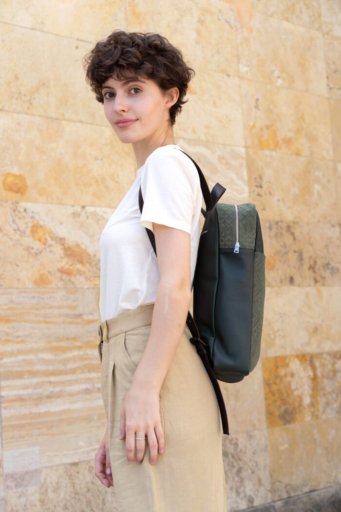 Model trägt frisch Beutel Rucksack Botanik in dunkelgrün mit Prägung