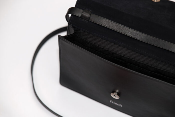 Detail einer schwarzen Handtasche von frisch mit abnehmbarem Träger in schwarz