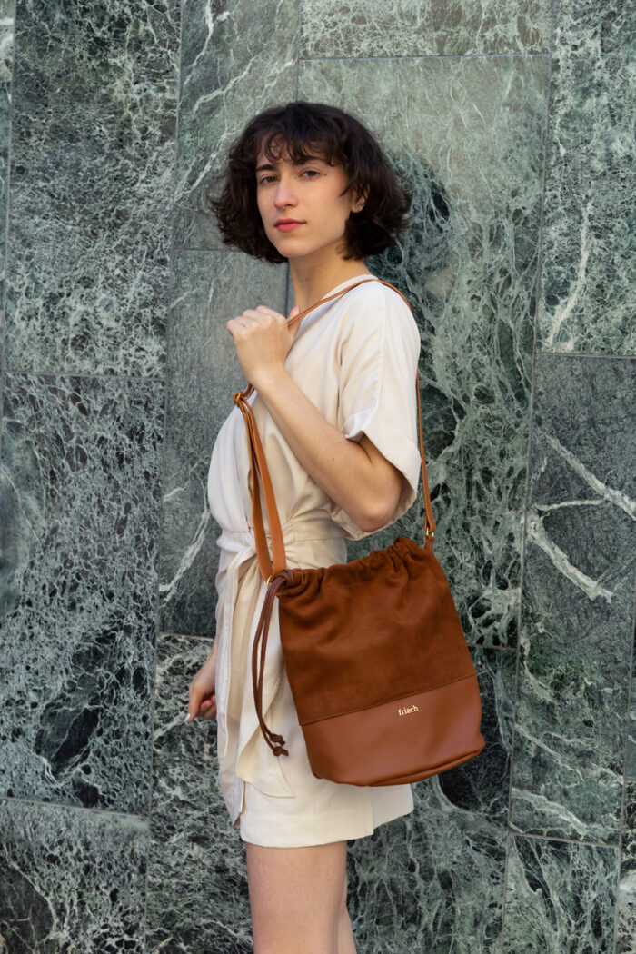 Model trägt frisch Beutel Tasche zum Umhängen aus Leder cognac