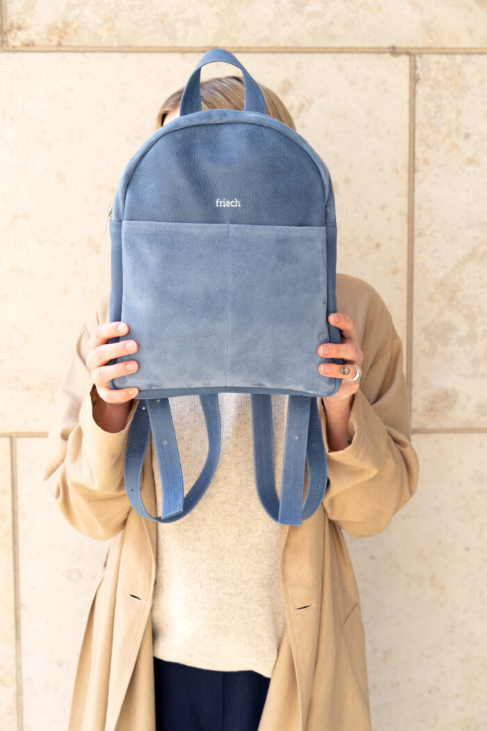 Produktbild kleiner Rucksack Luft von Modell vor dem Gesicht gehalten