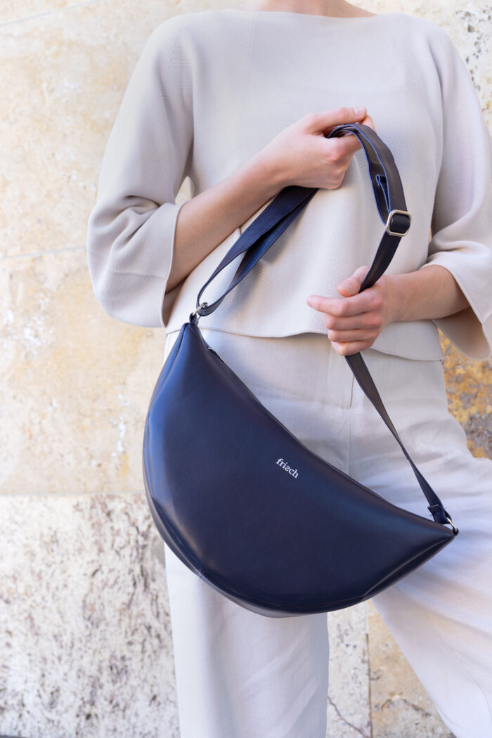 Model mit Handtasche aus dunkelblauem veganem Apfelleder